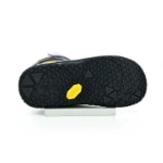 Suela negra de la bota Primigi Barefoot orchidea con dibujo de triángulos y logotipo amarillo de Vibram