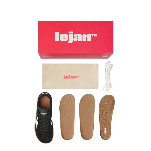 Contenido de una caja roja Lejan: zapatilla negra con detalles blancos, bolsa beige, cordones blancos y tres plantillas