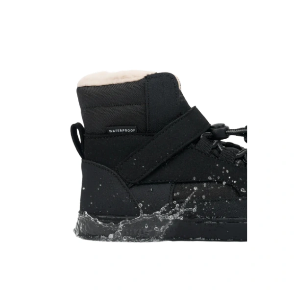 Vista lateral de la bota Muris baltic JR negro con forro beige, tira de velcro y agua salpicando la suela