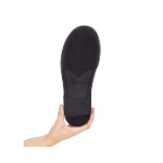 Suela negra de goma del zapato Barevene Oxford Bruno sostenido por una mano, con el logotipo y «Made in Spain» grabados