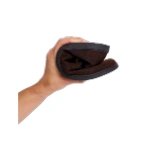 Zapato Barevene Oxford Bruno de ante marrón doblado en una mano para mostrar la flexibilidad de su suela negra