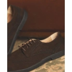 Zapatos Barevene Oxford Bruno de ante marrón con picado brogue y suela negra, sobre una alfombra estampada