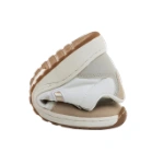 Zapatilla Mustang Free sneaker blanca doblada por la mitad, mostrando su suela flexible color caramelo