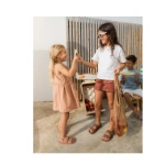 Niña con sandalias Muris Aruba Mini rosa compartiendo melón con otra niña con gafas de sol y un niño sentado