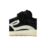 Detalle lateral de la zapatilla infantil Lejan Melrose Kids Noir, negra con velcro, piezas blancas y suela crudo